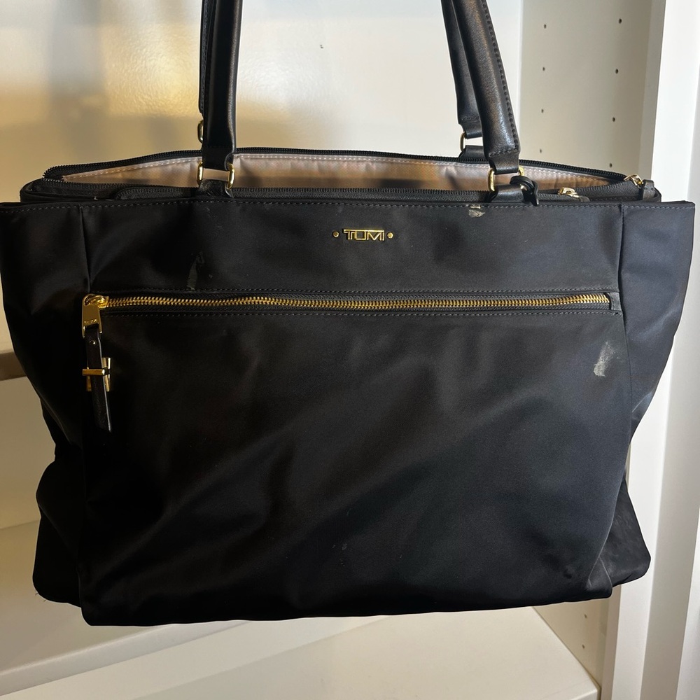 Tumi women’s computer-travel bag.  Magnetic closures many organizing pockets.